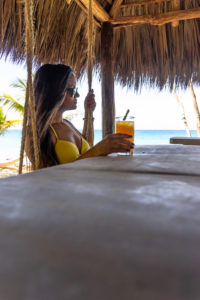 Amerika, Karibik, Große Antillen, Dominikanische Republik, Cabarete, Frau sitzt auf einer Schaukel an der Strandbar und trinkt einen Cocktail im Natura Cabana Boutique Hotel & Spa Amerika, Karibik, Große Antillen, Dominikanische Republik, Cabarete, Frau sitzt auf einer Schaukel an der Strandbar und trinkt einen Cocktail im Natura Cabana Boutique Hotel & Spa